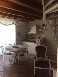 Emily house في بوزالو: مطبخ مع طاولة وكراسي في غرفة