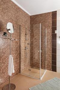 a bathroom with a shower with glass doors at Pannonhalma Panzió in Pannonhalma