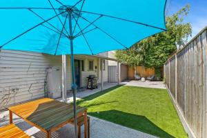 a blue umbrella in the backyard of a house at Mid Century 1930 Beautifully renovated Californian Bunglow in Newtown and Chilwell +5 photos