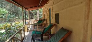 a porch of a house with chairs on it at Bardia hostel in Bhurkīā
