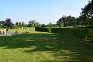 a large grassy yard with chairs and a flag at Cherry Farmhouse in York
