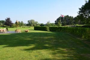 ein großer Rasengarten mit Stühlen und einer Flagge in der Unterkunft Cherry Farmhouse in York