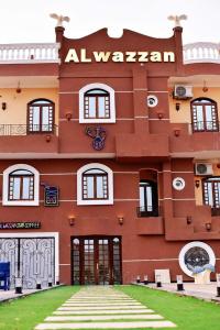 a large red building with a sign on it at Elwazan Hotel in Quseir