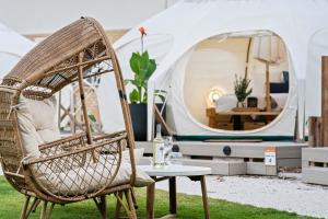 a wicker chair and a table in front of a tent at Ingenia Holidays Byron Bay in Byron Bay