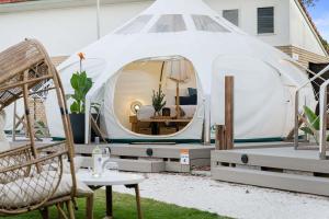 a white iguana tent with a table and a chair at Ingenia Holidays Byron Bay in Byron Bay