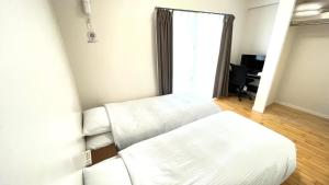 um quarto com uma cama e uma secretária com uma janela em Condominium GOLF GOLF Tsuboya em Naha