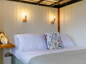 uma cama com uma almofada e duas luzes na parede em Foxglove - Uk37639 em Bradbourne