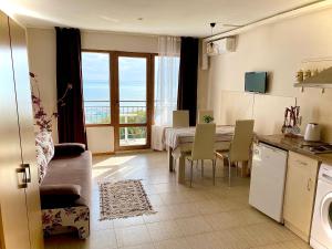 a kitchen and dining room with a table with a view at Family Hotel Rai-Only Adults in Golden Sands