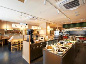 eine große Küche mit vielen Tellern an der Theke in der Unterkunft Sotetsu Fresa Inn Kitahama in Osaka