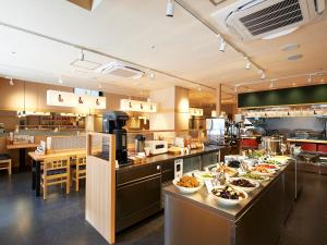 a large kitchen with many plates of food on the counters at Sotetsu Fresa Inn Kitahama in Osaka