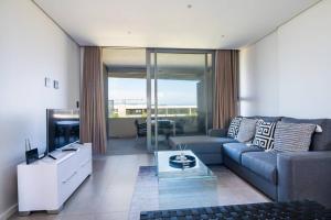 a living room with a couch and a tv at Pebblebeach 2 bedroom Apartment in Sibaya
