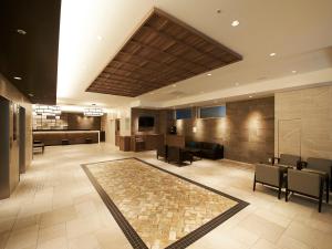 a lobby with a waiting area with chairs and tables at Sotetsu Fresa Inn Kitahama in Osaka