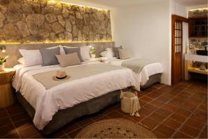 a bedroom with two beds and a stone wall at Casa Catarina in Sololá