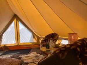 a tent with a table and chairs in it at A Romantic & Luxurious stay in the nature of Karula National Park. in Ähijärve