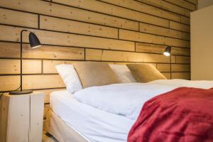 1 Schlafzimmer mit 2 Betten und einer Holzwand in der Unterkunft Kuckucksnester Titisee in Titisee-Neustadt