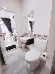 een witte badkamer met een toilet en een wastafel bij PPhouse Boutique House Phuket Town in Ban Bang Khu