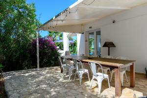 a wooden table and chairs on a patio at Villa Amarantos in Santa Eularia des Riu