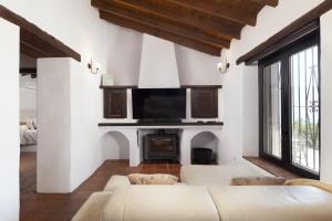 een woonkamer met een bank en een tv bij Finca Mojito in Cómpeta
