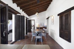 een eetkamer met witte muren en een tafel en stoelen bij Finca Mojito in Cómpeta