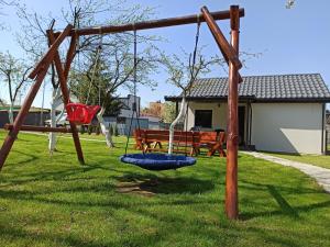 un parque infantil con un columpio en un patio en Noclegi NAD NILEM, en Zator