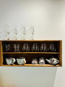 una mensola in legno con bicchieri da vino e tazze sopra di １日１組様限定「レジデンス」 a Nagano