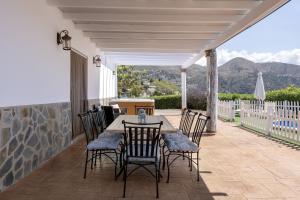 a patio with a table and chairs on a deck at Casa Rural el Cerrillo in Cómpeta