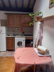 eine Küche mit einem Tisch und einem rosa Tischtuch in der Unterkunft BIRI in Perugia