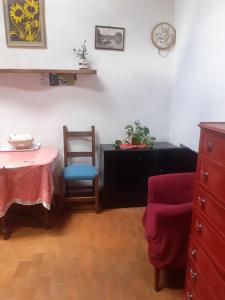 Zimmer mit einem Tisch, 2 Stühlen und einer Uhr in der Unterkunft BIRI in Perugia