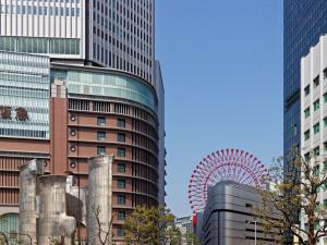 eine Stadt mit hohen Gebäuden und einem Riesenrad in der Unterkunft Sotetsu Fresa Inn Kitahama in Osaka