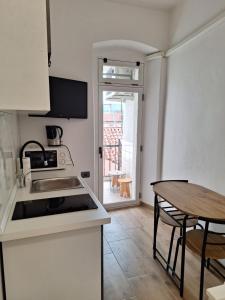 a kitchen with a sink and a table with a table at Apartma Koper2 with parking in Koper
