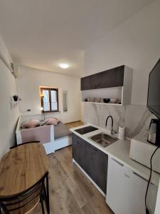 a kitchen and living room with a sink and a table at Apartma Koper2 with parking in Koper