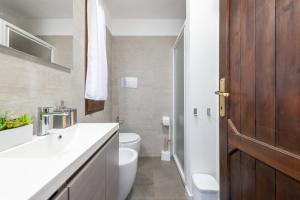 La salle de bains est pourvue de toilettes et d'une porte en bois. dans l'établissement Villa Princy, à Torre delle Stelle