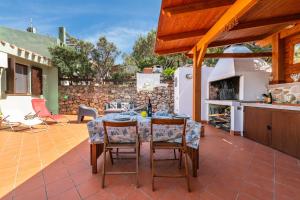 een patio met een tafel en stoelen en een keuken bij Villa Princy in Torre delle Stelle