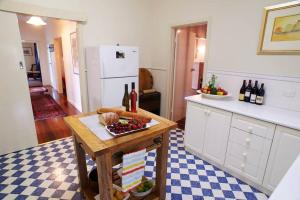 a kitchen with a table with a plate of fruit and wine bottles at Asrama Albany in Albany