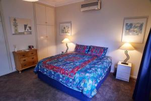 a bedroom with a large bed with two lamps on it at Asrama Albany in Albany