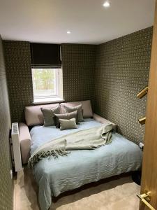 a bedroom with a large bed with a window at Gleneagles Holiday Home Rental in Auchterarder