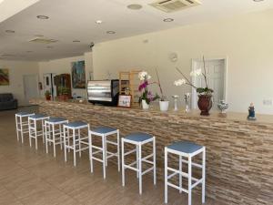 a bar with a row of stools in a room at Protaras Tennis and Country Club in Protaras