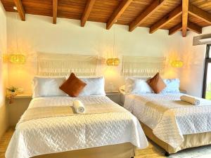 1 Schlafzimmer mit 2 Betten und weißen Bettdecken in der Unterkunft Villa Boho in Panajachel