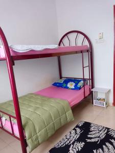 een slaapkamer met 2 stapelbedden en een tapijt bij Malin's Homestay Kota Bharu in Kota Bharu
