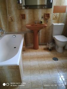 uma casa de banho com uma banheira, um WC e um lavatório. em Avra em Artemida