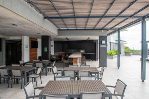 a patio with tables and chairs and a kitchen at Lux Holiday Apartment Sibaya in Umdloti