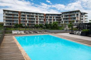 a swimming pool in front of a building at Lux Holiday Apartment Sibaya in Umdloti