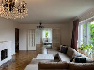 a living room with a couch and a fireplace at Grand villa with great location! in Gothenburg