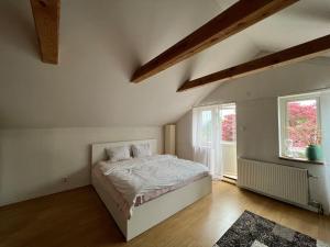 a white bedroom with a bed and a window at Grand villa with great location! in Gothenburg