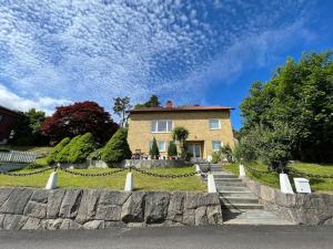 a house on a hill with a stone wall at Grand villa with great location! in Gothenburg