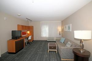 a living room with a couch and a tv at TownePlace Suites by Marriott Aiken Whiskey Road in Aiken