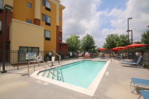 einen Pool in einem Hotel mit Stühlen und Sonnenschirmen in der Unterkunft TownePlace Suites by Marriott Aiken Whiskey Road in Aiken