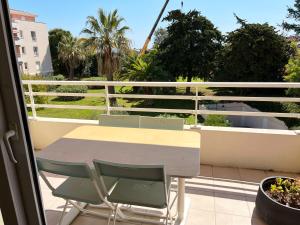 een tafel en stoelen op een balkon met uitzicht bij Appartement 84m² avec 2 parkings privatifs in Villeneuve-Loubet