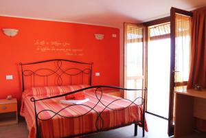um quarto vermelho com uma cama com uma parede vermelha em B&B L'alba Nel Golfo em Castelsardo