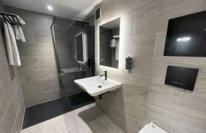 a bathroom with a white sink and a shower at Lydiard Park Hotel in Swindon